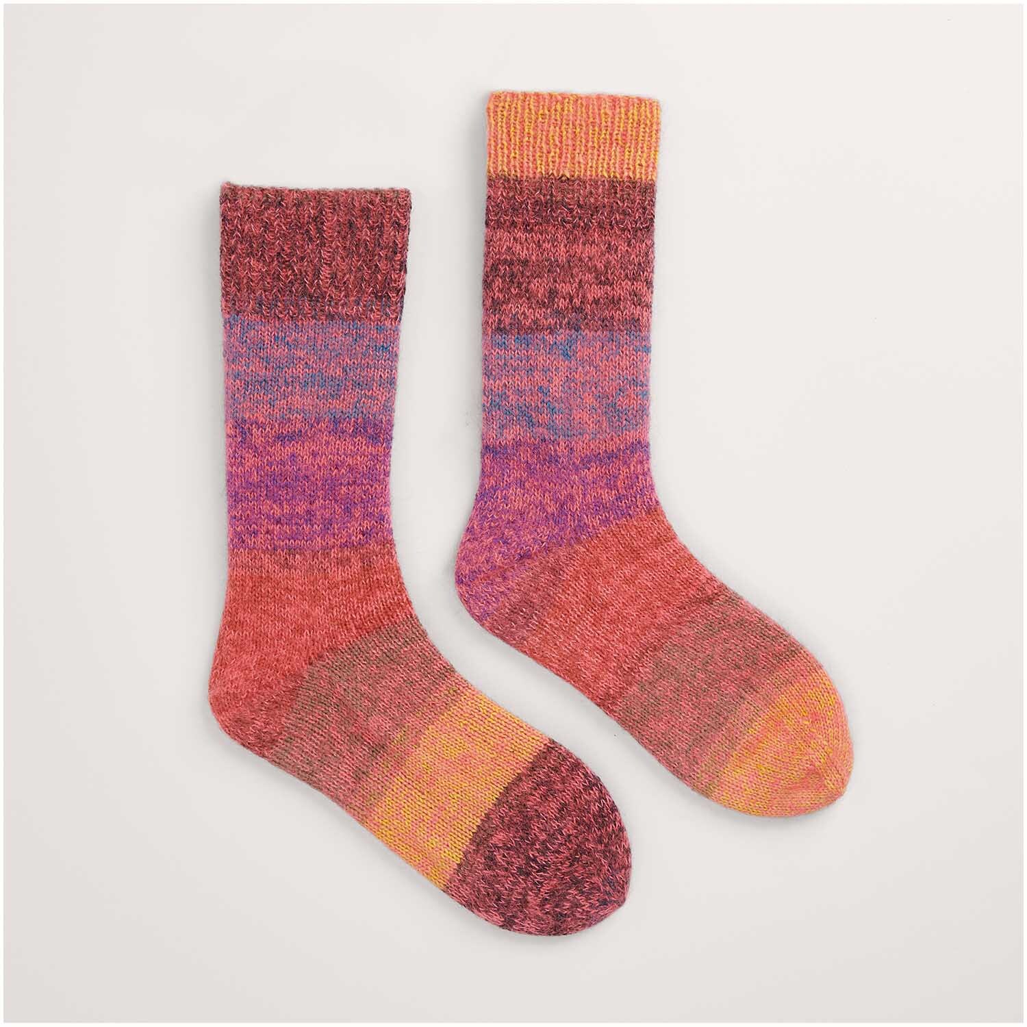Buntes Strickset für Socken, Modell 45 aus "Made by Me Nr. 17". Die Socken zeigen ein Farbverlaufsmuster in Rot, Orange und Lila. Perfekt für kreative Strickprojekte.