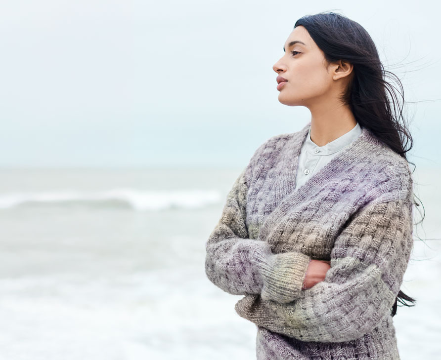 Frau trägt Strickjacke mit Farbverlauf von Lila nach Grün