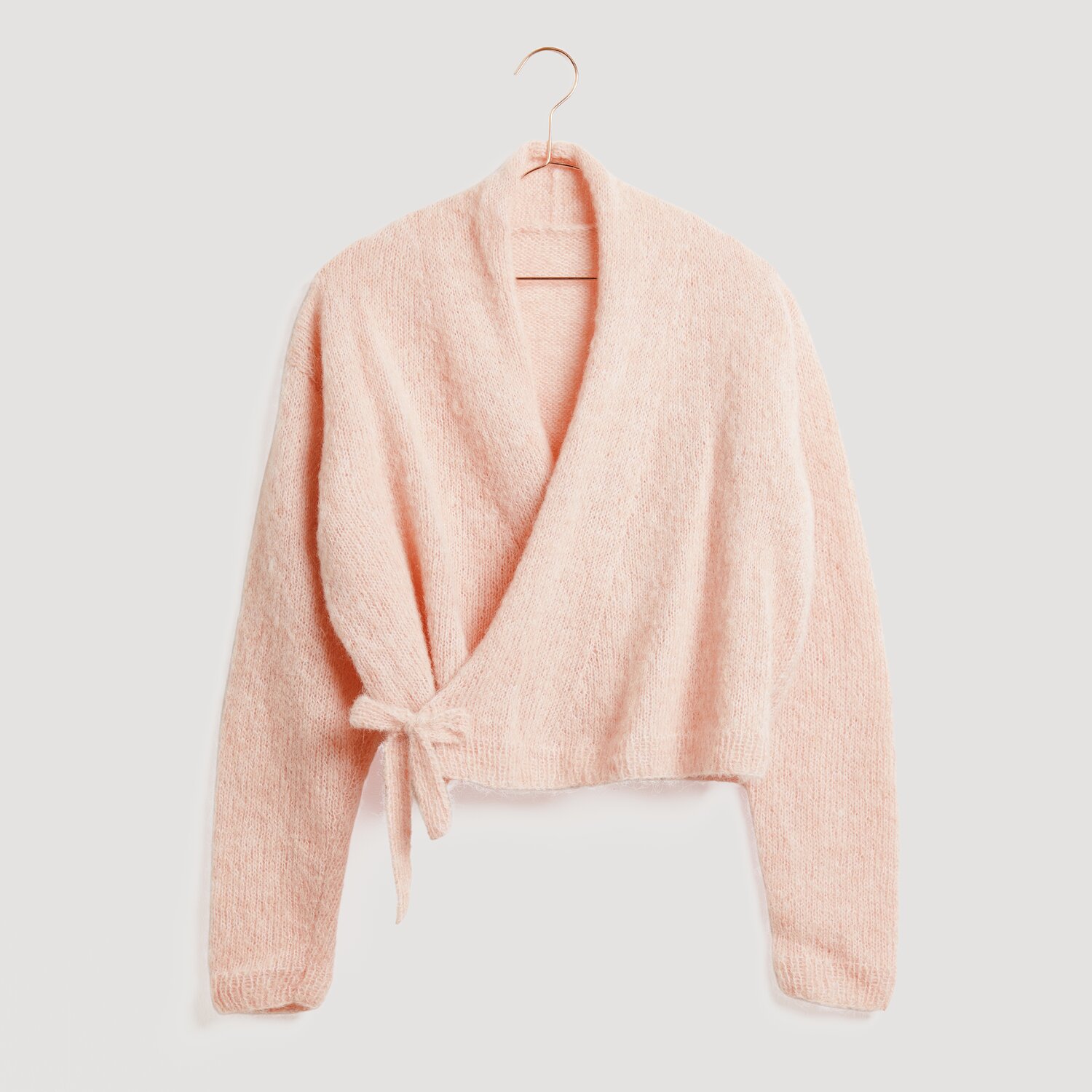 Weiches, rosa Wickeloberteil von Modell Legeware, auf einem Kleiderbügel präsentiert. Ideal für gemütliche Anlässe, vereint es Stil und Komfort in einem eleganten Design.