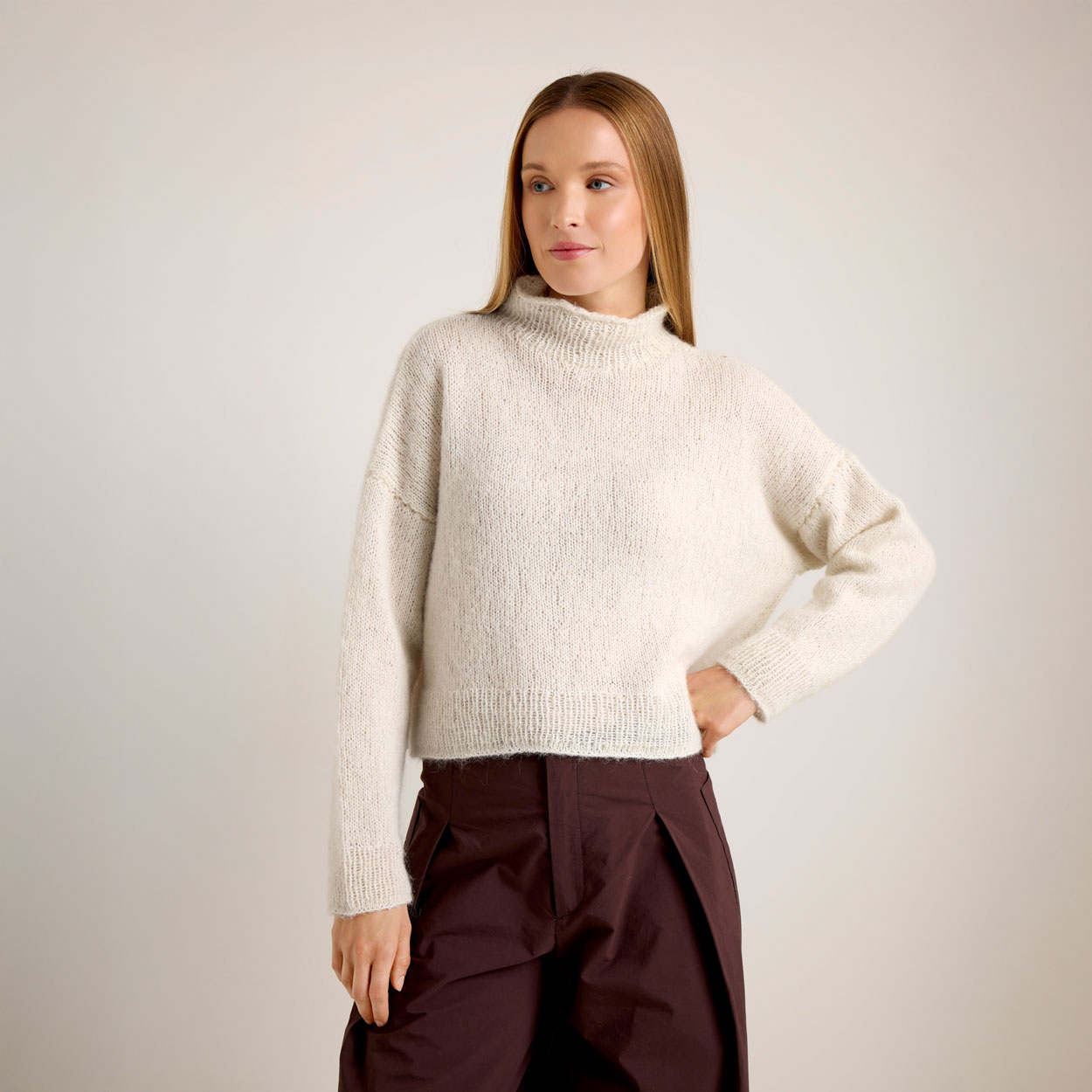 Frau trägt einen weißen Strickpuli