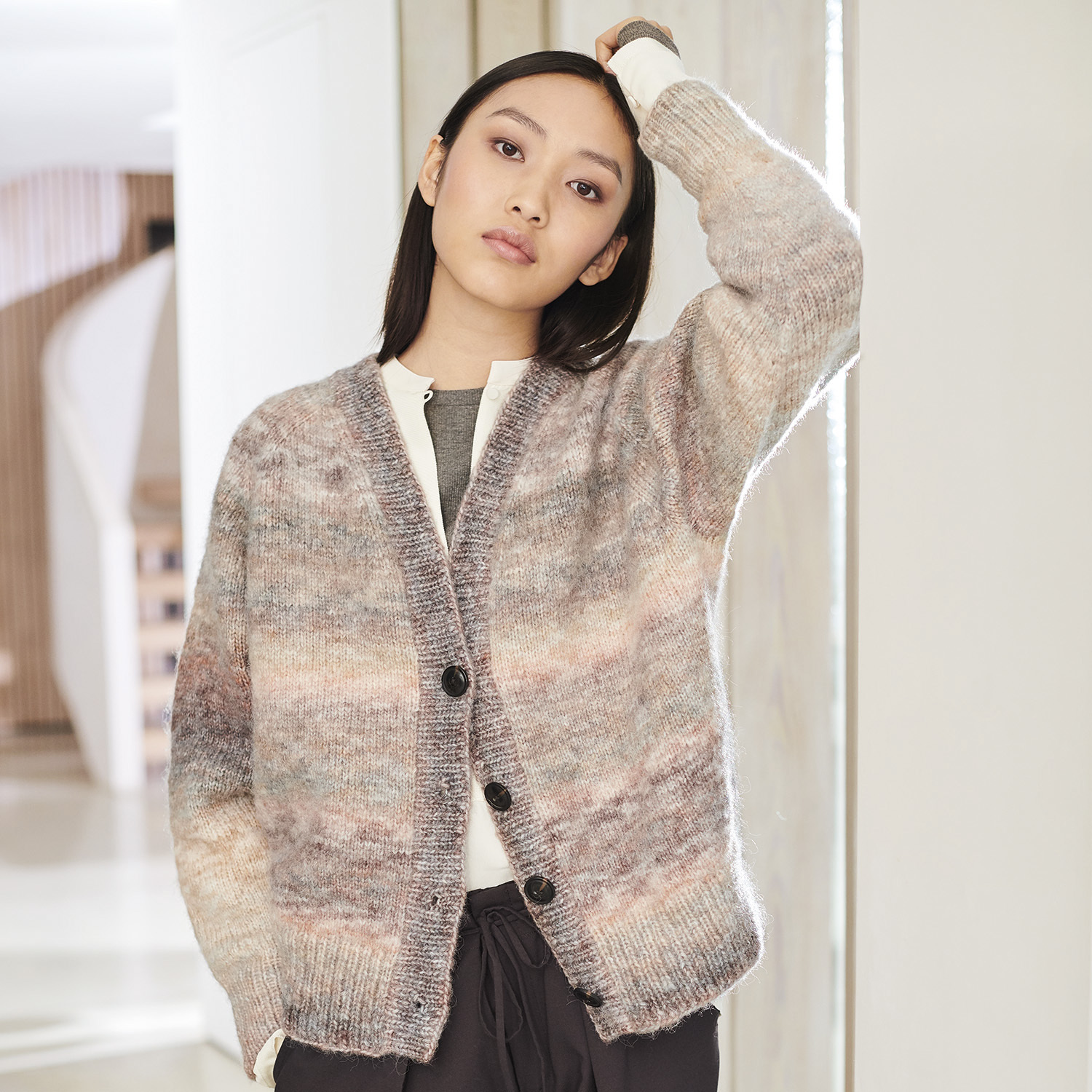 Strickanleitung Jacke aus Creative Painted Power: Frau trägt melierte Strickjacke mit Knöpfen.