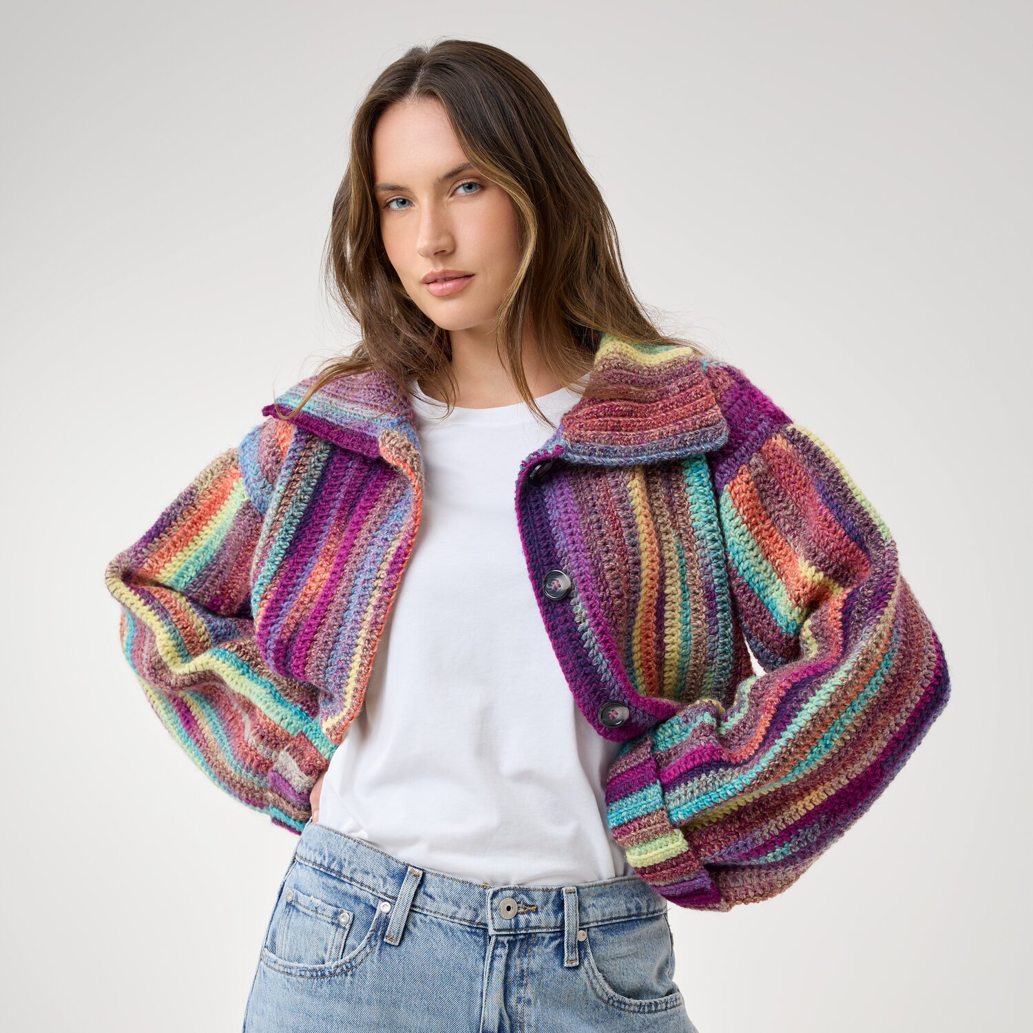 Häkelset Jacke Modell 19 aus Die Neue Masche No. 16, kurz geschnittene, bunt gestreifte Häkeljacke mit Knöpfen, getragen von Frau zu Jeans und T-Shirt