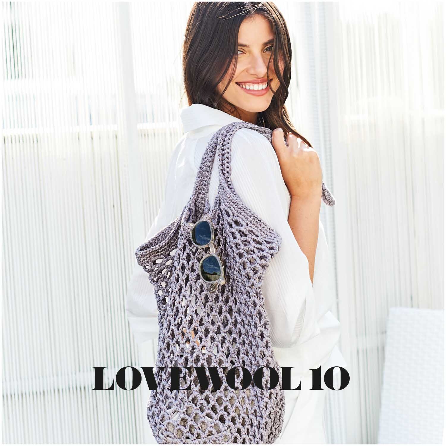 Fashion Cotton Métallisé dk: Frau mit gehäkelter Tasche aus Eisen-grauem Garn, lächelnd in weißem Outfit.
