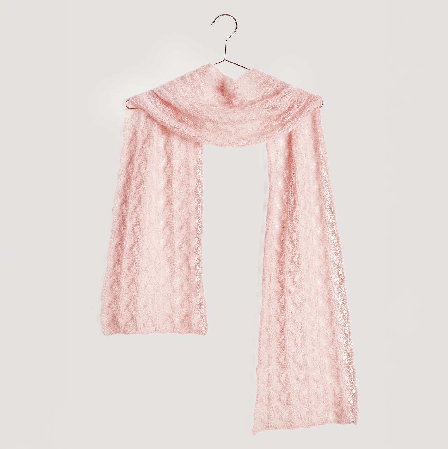 Strickset Tuch Modell 13: Zartes, rosa Tuch aus Mohair-Seide-Mischung, elegant drapiert auf einem Kleiderbügel.