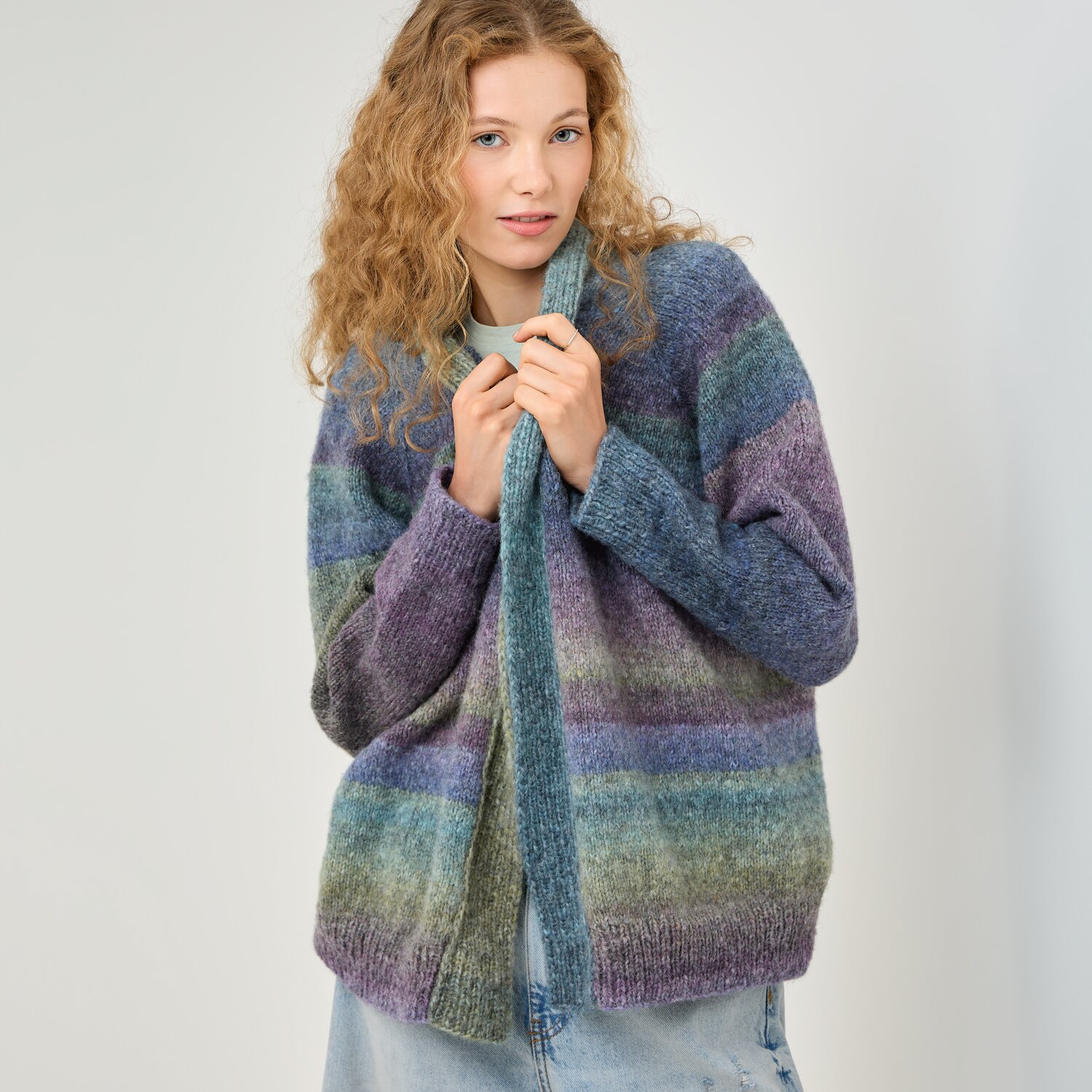 Strickset Jacke Modell 22 aus Die Neue Masche No. 16, locker geschnittene Damenstrickjacke mit weichen Farbverläufen in Blau, Violett und Grün, getragen von junger Frau