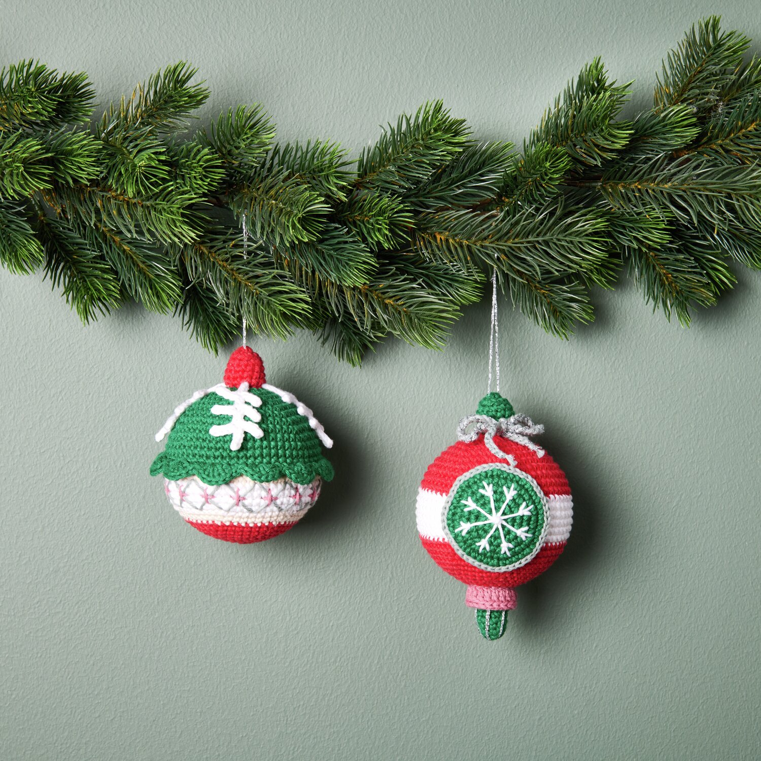 Ricorumi Häkelset Christbaumkugeln Silber 2 Stück von Rico Design Ricorumi Häkelset Christbaumkugeln Silber: Zwei gehäkelte Kugeln in Rot und Grün an Tannenzweigen.