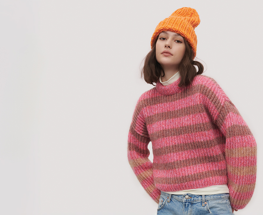 Frau mit gestreiftem Strickpullover und Mütze