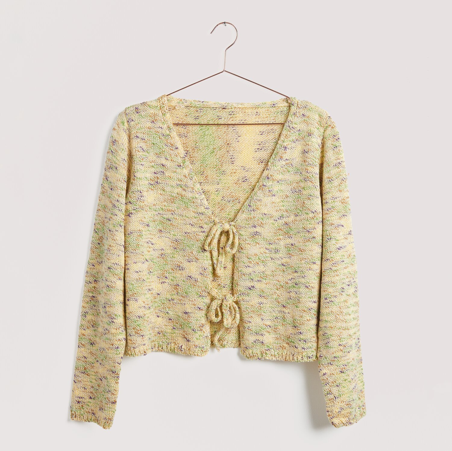 Helle, gestrickte Jacke mit Schleifen auf Bügel