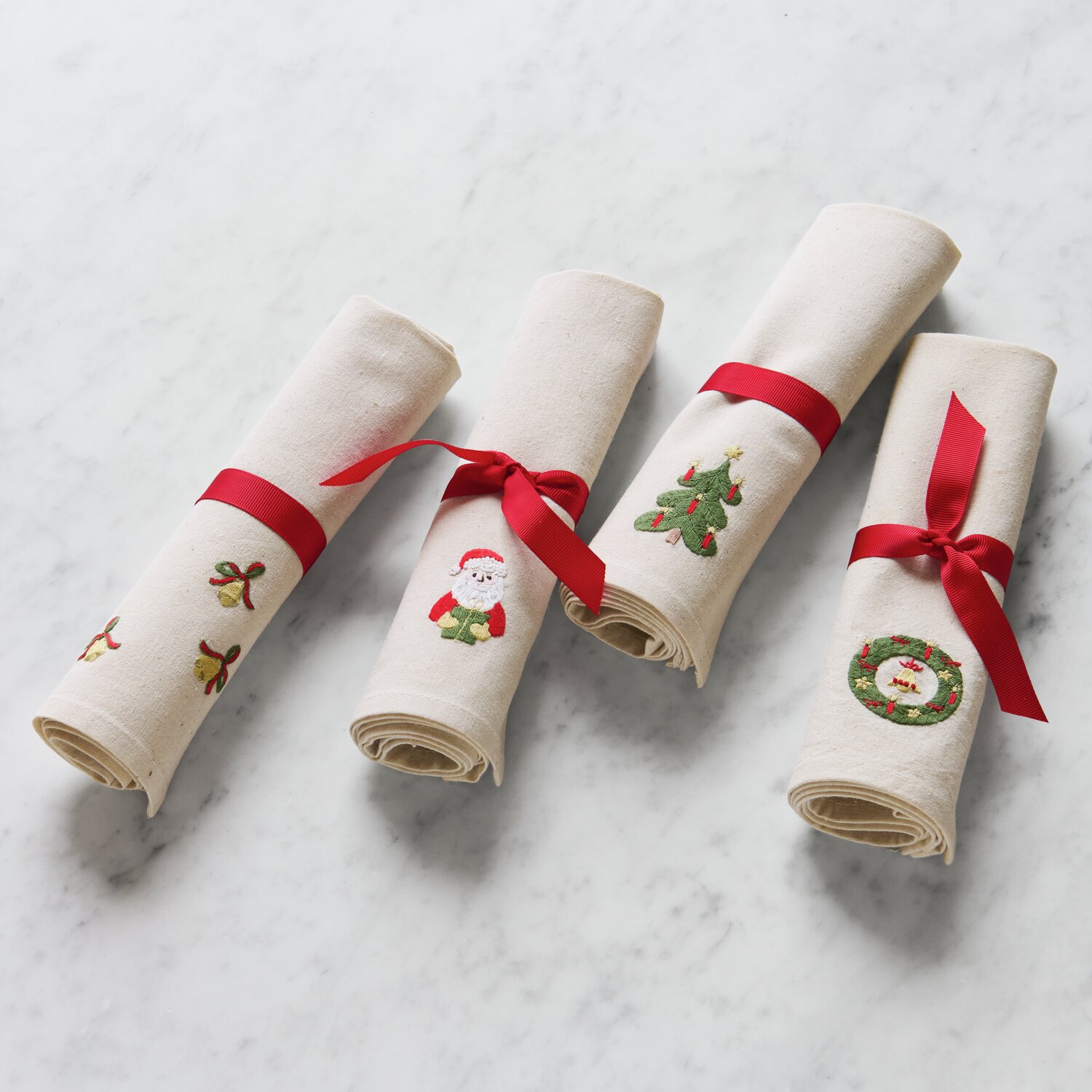 Stick & Stitch Stickpackung Weihnachtsmann 13 Stück zeigt bestickte Servietten mit roten Schleifen, gestaltet von Rico Design.