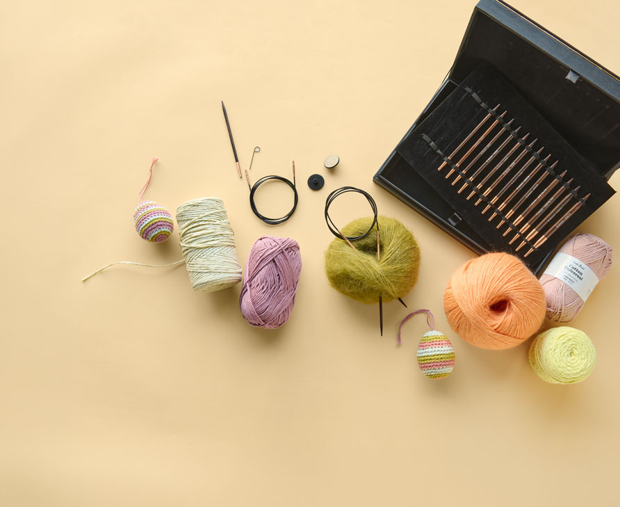Stricknadel-Set, Wollknäuel und gehäkelte Ostereier
