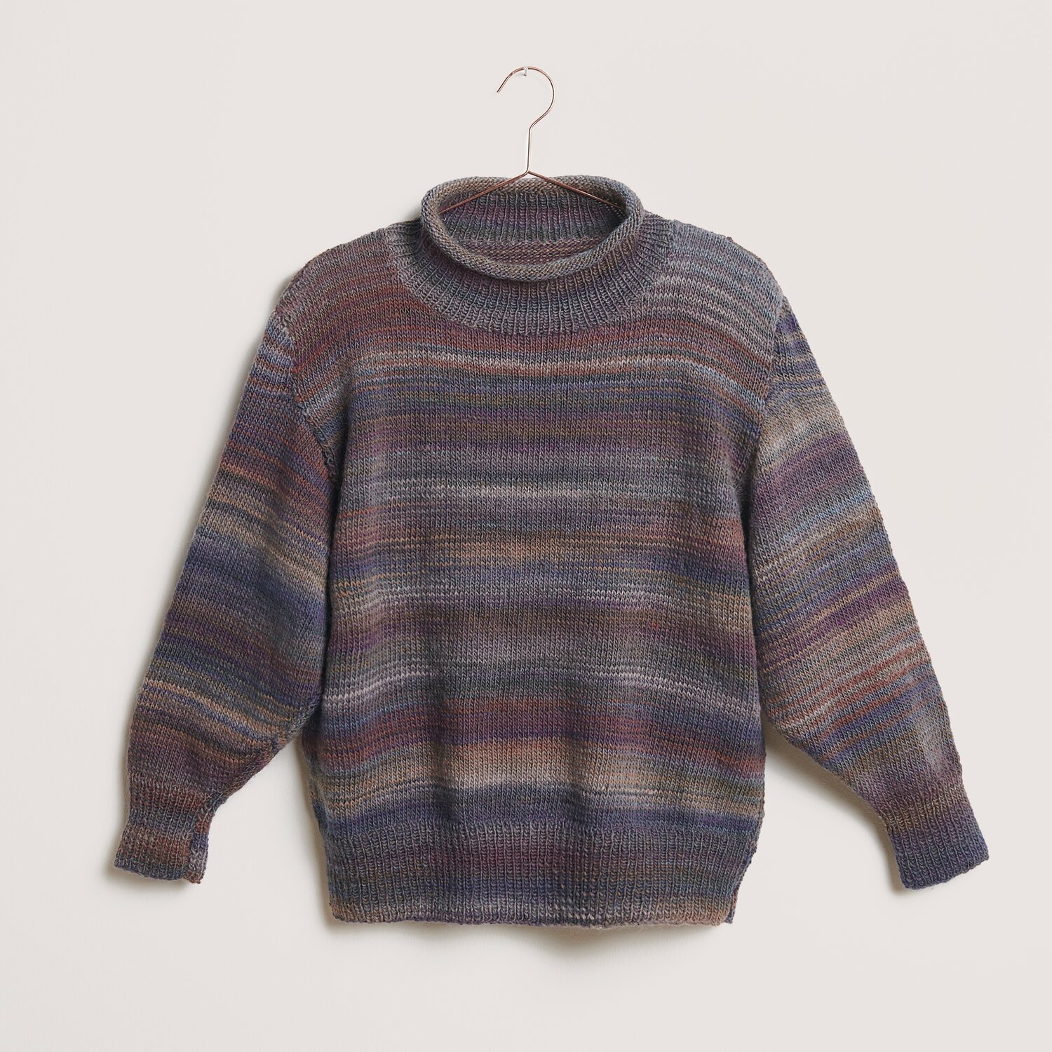 Creative Melange aran Wonderball: Bunter Strickpullover mit Rollkragen, ideal für den Winter.