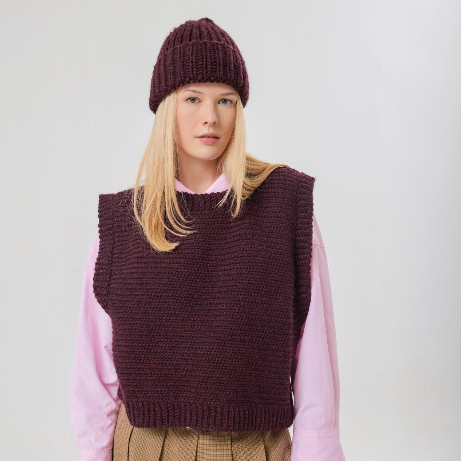 Häkelset Pullunder Modell 27 aus Made by Me No. 21: Frau trägt weinroten Pullunder und Mütze über rosa Hemd.