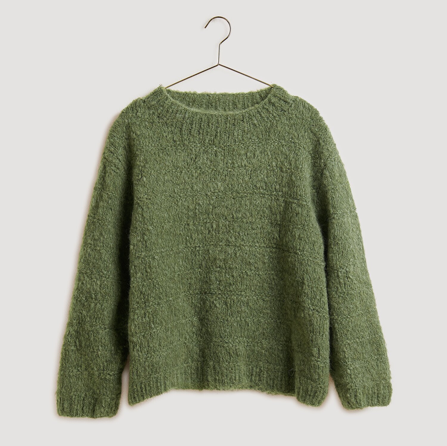 Strickset Pullover Modell 21 in Oliv aus Fashion Alpaca Superfine Heavens Uni, präsentiert auf einem Kleiderbügel. Ideal für die Herbstsaison.