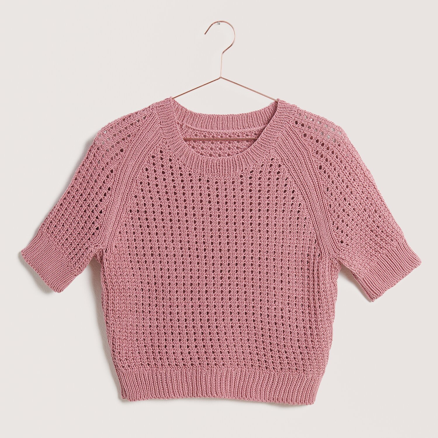 Strickset Shirt Modell 12 kurz aus Die Neue Masche Nr. 9 von idee. Creativmarkt Strickset Shirt Modell 12 kurz aus Die Neue Masche Nr. 9, rosa, mit kurzem Ärmel und Lochmuster, ideal für Frühling und Sommer.