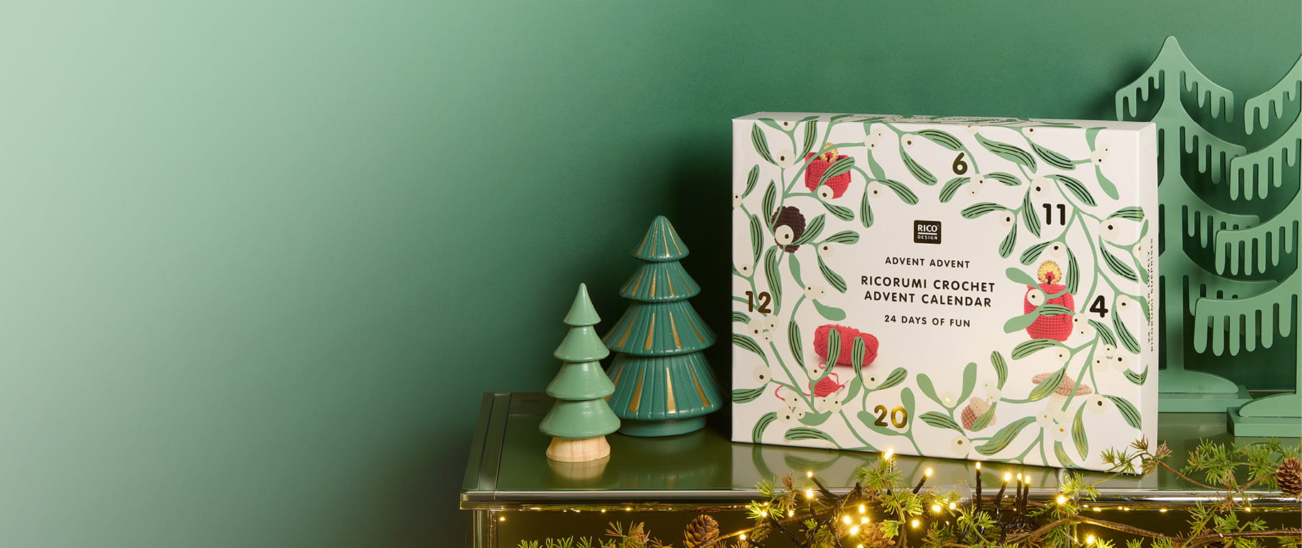 Ricorumi Adventskalender steht auf Kamin, daneben dekorative Bäume