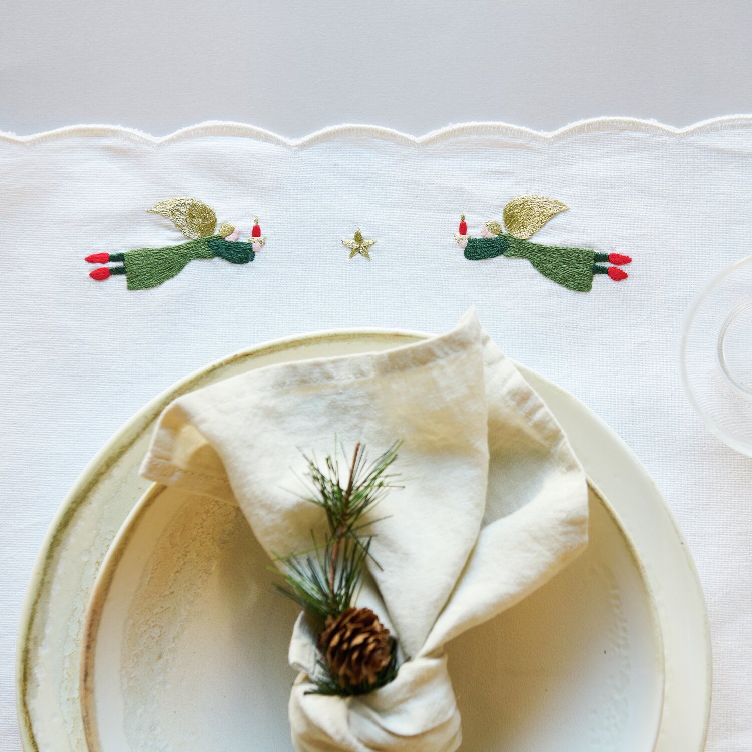 Stick & Stitch Stickpackung Engel mit Kerzen zeigt zwei gestickte Engel auf weißem Stoff, ideal für festliche Tischdekorationen.