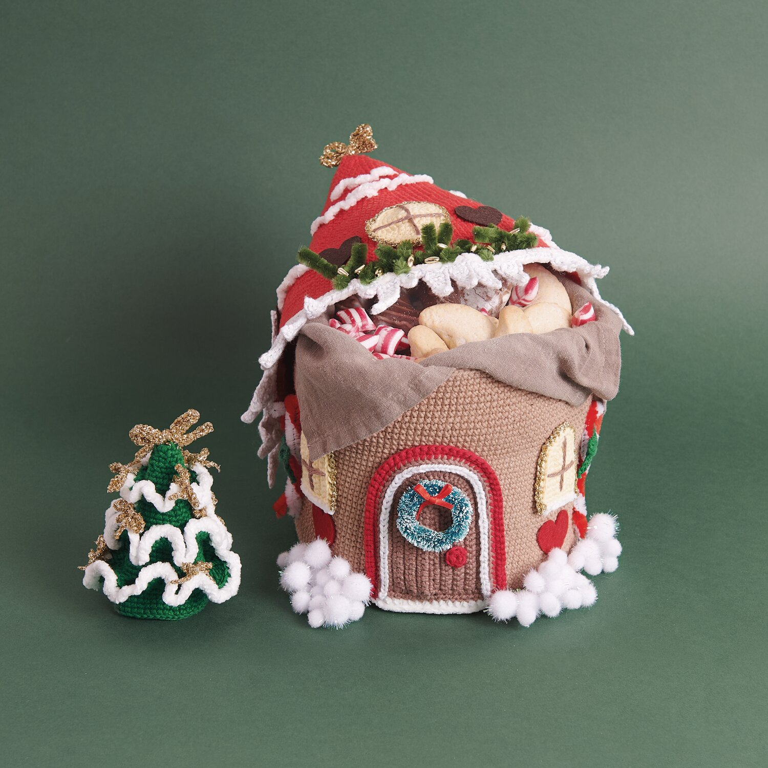 Ricorumi Adventskalender: Handgemachtes Häuschen mit weihnachtlichen Details und kleinem Baum. Ideal für festliche Dekorationen.