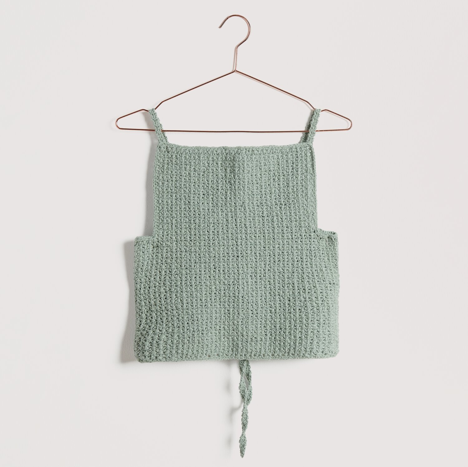 Gehäkeltes Top in türkis auf Bügel