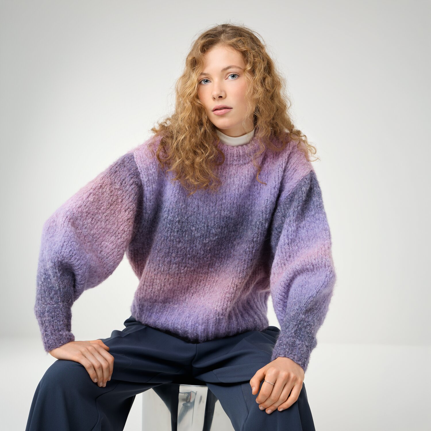 Strickset Pullover Modell 25 aus Die Neue Masche No. 16, locker geschnittener Damenpullover mit weichem Farbverlauf in Lila- und Rosatönen, getragen von junger Frau