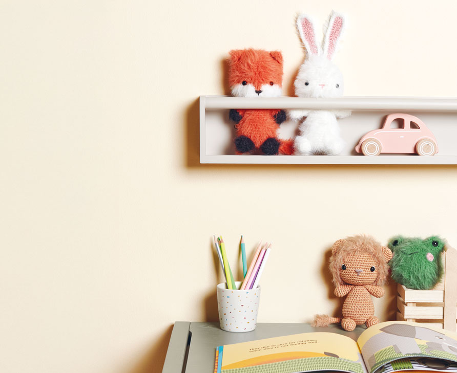 Gehäkelte Ricorumi-Figuren Fuchs und Hase sitzen im Regal, darunter Frosch und Löwe auf einem Schreibtisch