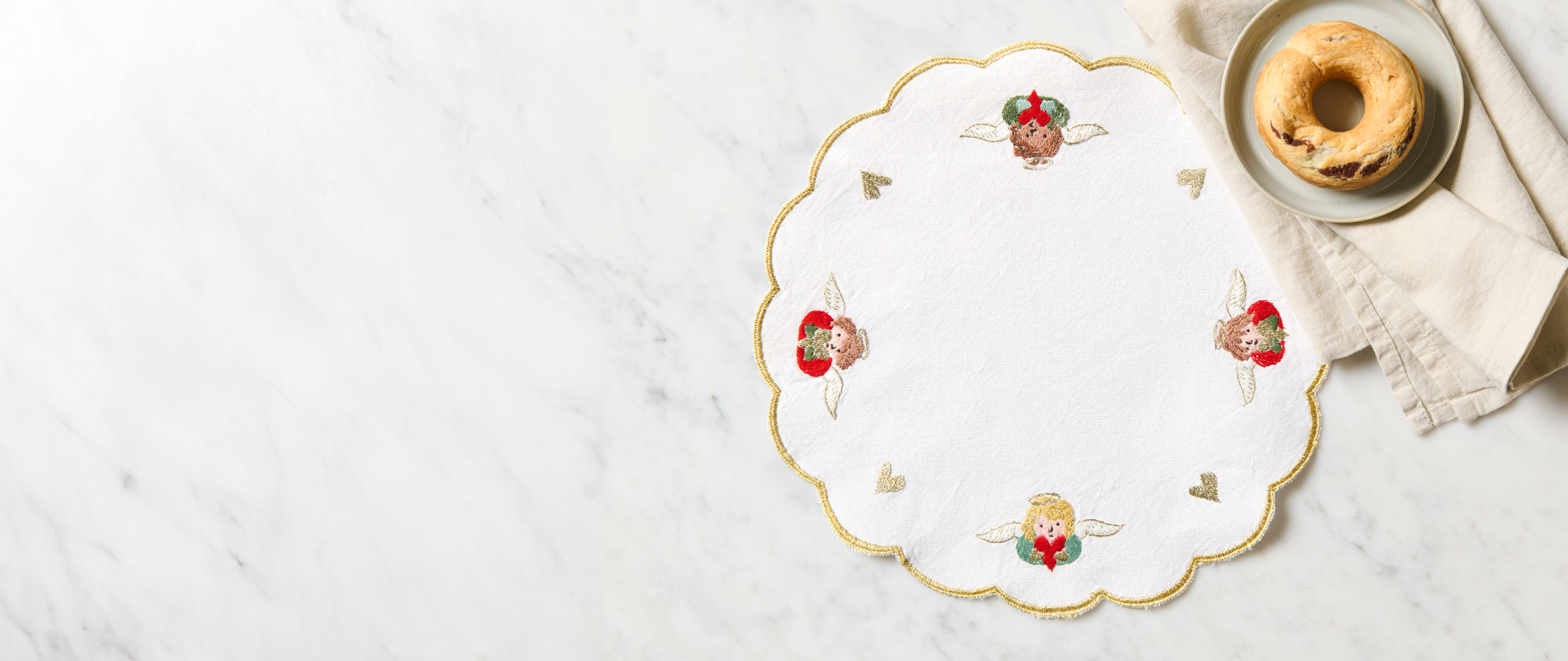 Besticktes Weihnachtsdeckchen liegt auf Tisch