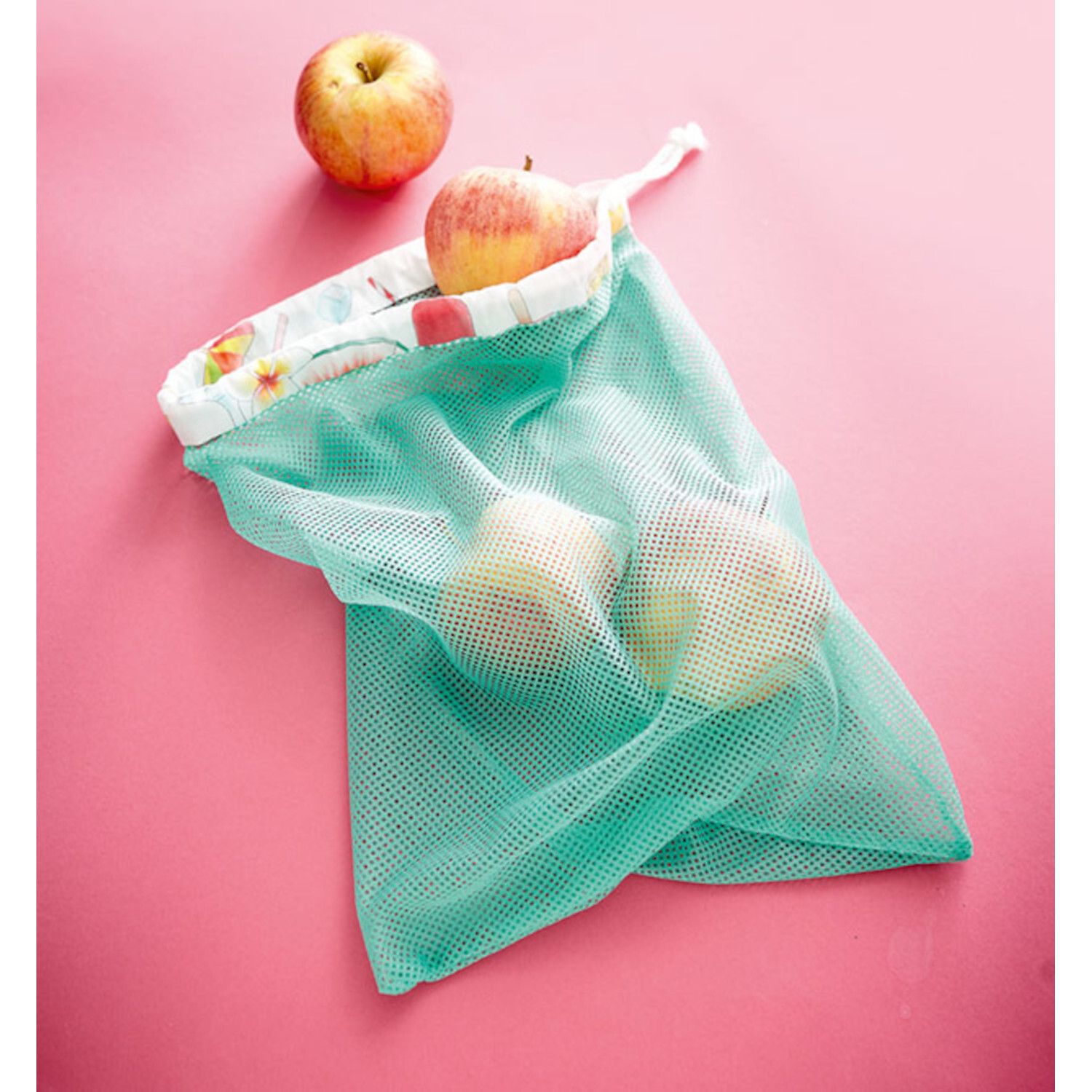 Näh-Quickies: 15-Minuten-Projekte - Wiederverwendbarer Netzbeutel in Türkis mit Äpfeln auf rosa Hintergrund. Ideal für umweltfreundliches Einkaufen.