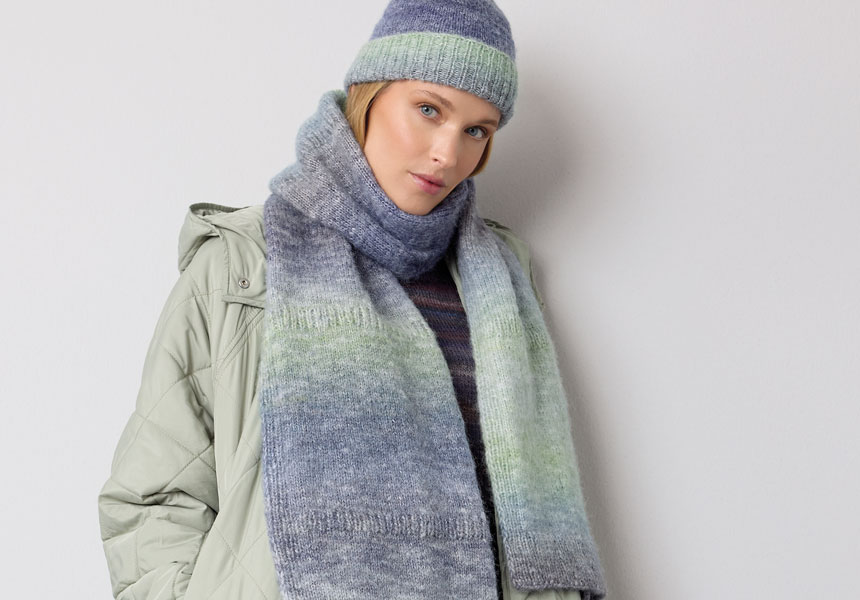 Frau trägt gestrickten Schal und gestrickte Mütze