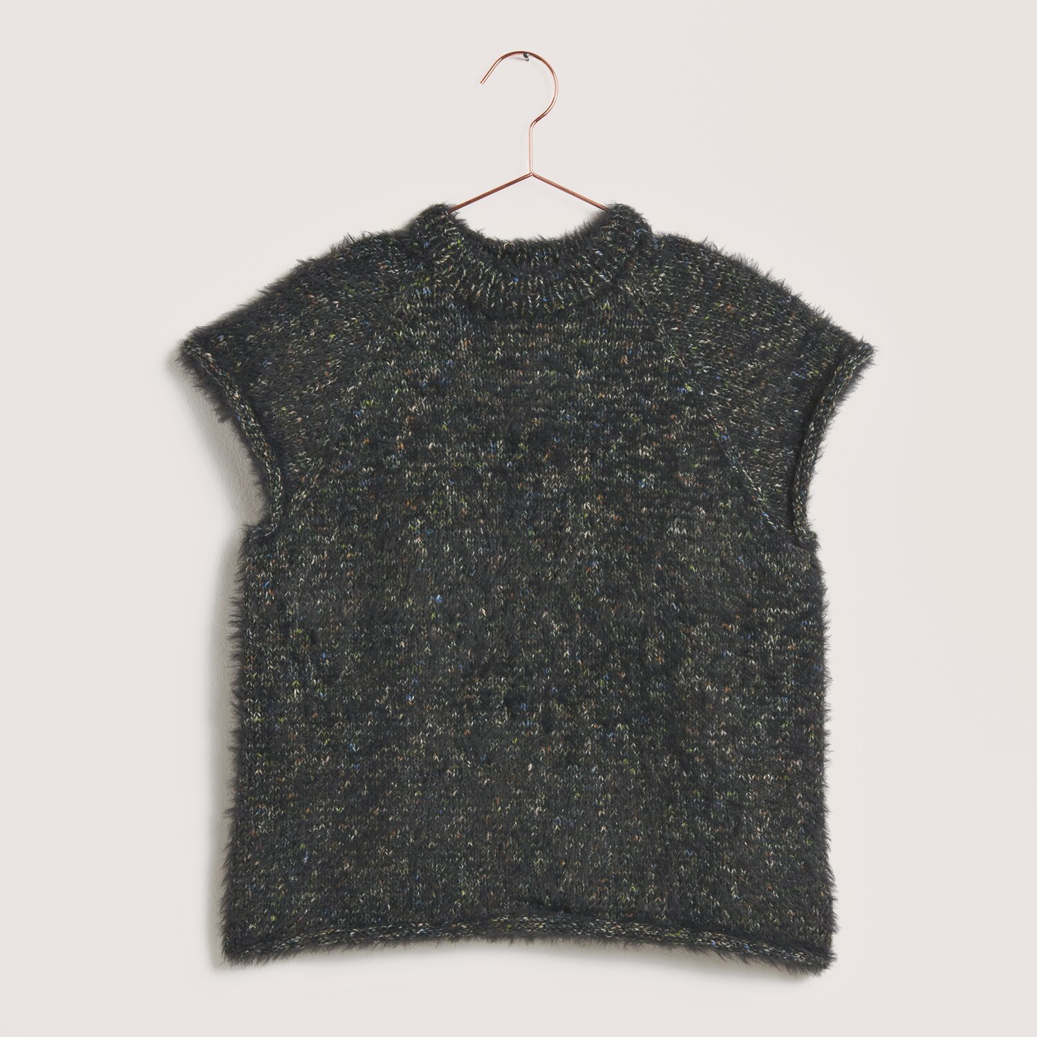 Creative Make It Fur: Dunkelgrüner, kurzärmeliger Pullover aus weichem Garn, hängend an einem roségoldenen Bügel.