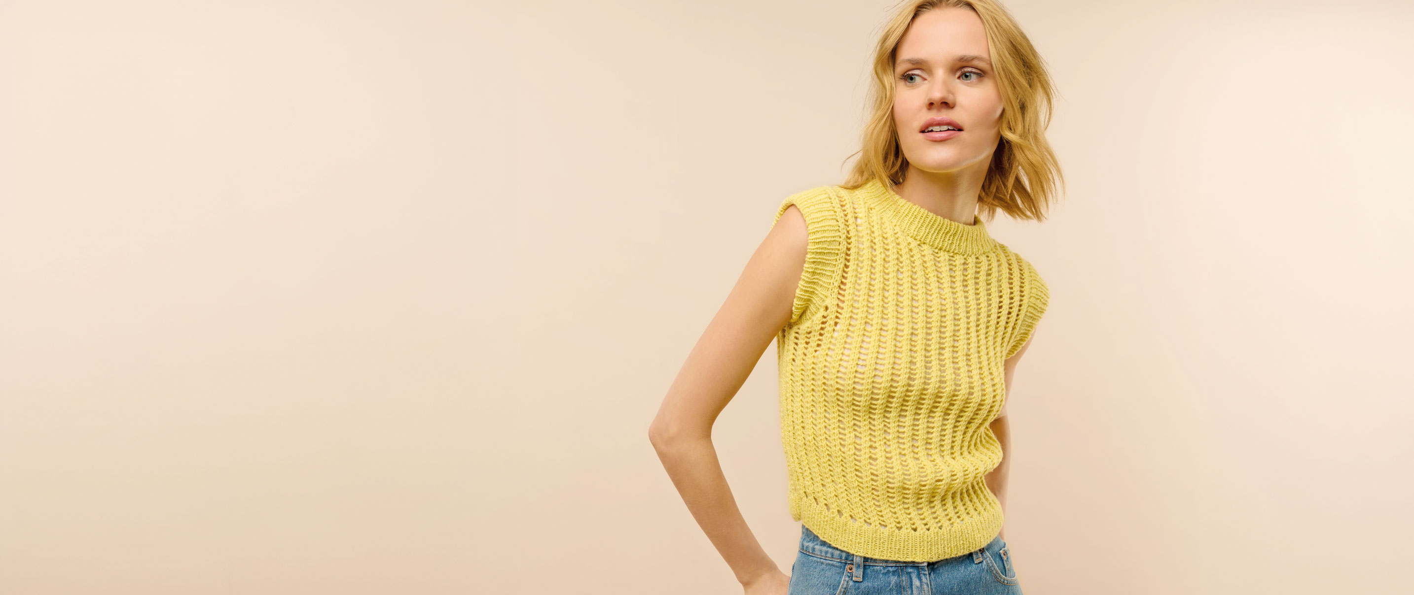 Frau trägt gelbes Stricktop