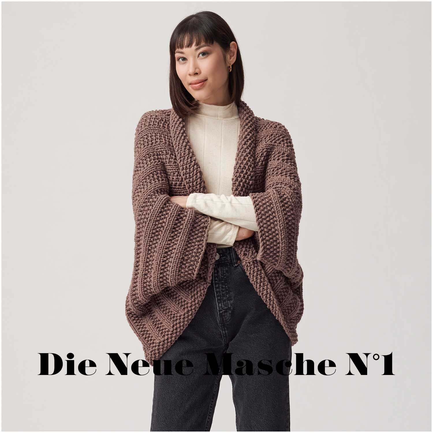 Polar 50g 45m Farbe Taupe von idee. Creativmarkt Polar: Frau trägt taupefarbenen Strickmantel aus Wolle Rödel, 50g 45m, vor neutralem Hintergrund.