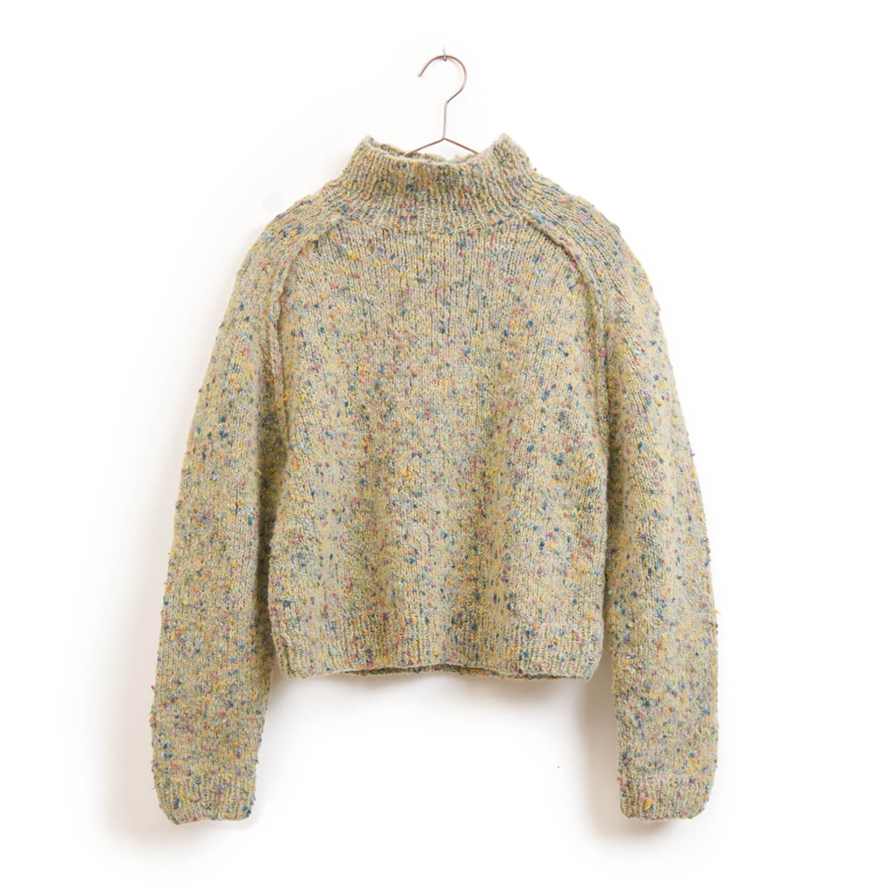 Hellbeiger Pullover mit bunten Sprenkeln, hohem Kragen und langen Ärmeln auf einem Kleiderbügel