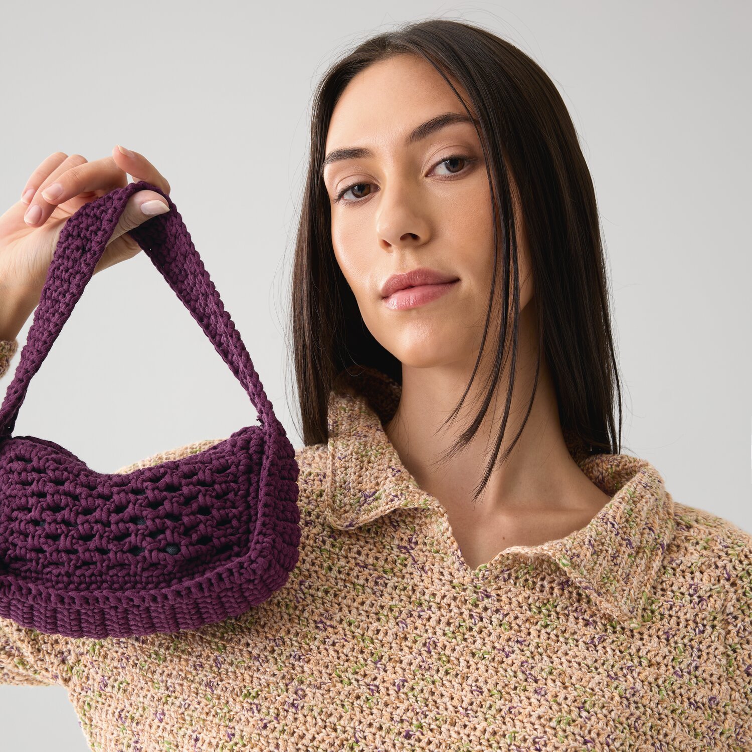 Häkelset Mini-Häkeltasche Modell 11 B: Frau hält lila Tasche aus Die Neue Masche No. 15.