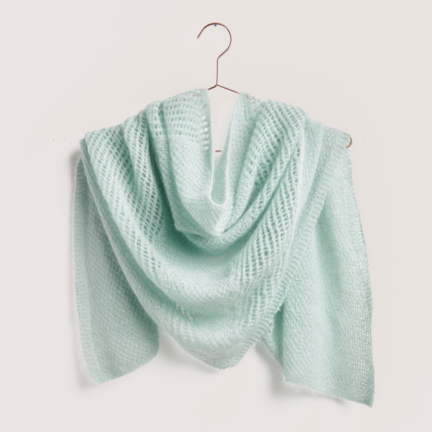 Strickset Dreieckstuch Modell 13 aus Tücher Special in zartem Aqua, gehäkelt aus luxuriösem Mohair-Seide-Garn, elegant drapiert auf einem Bügel.