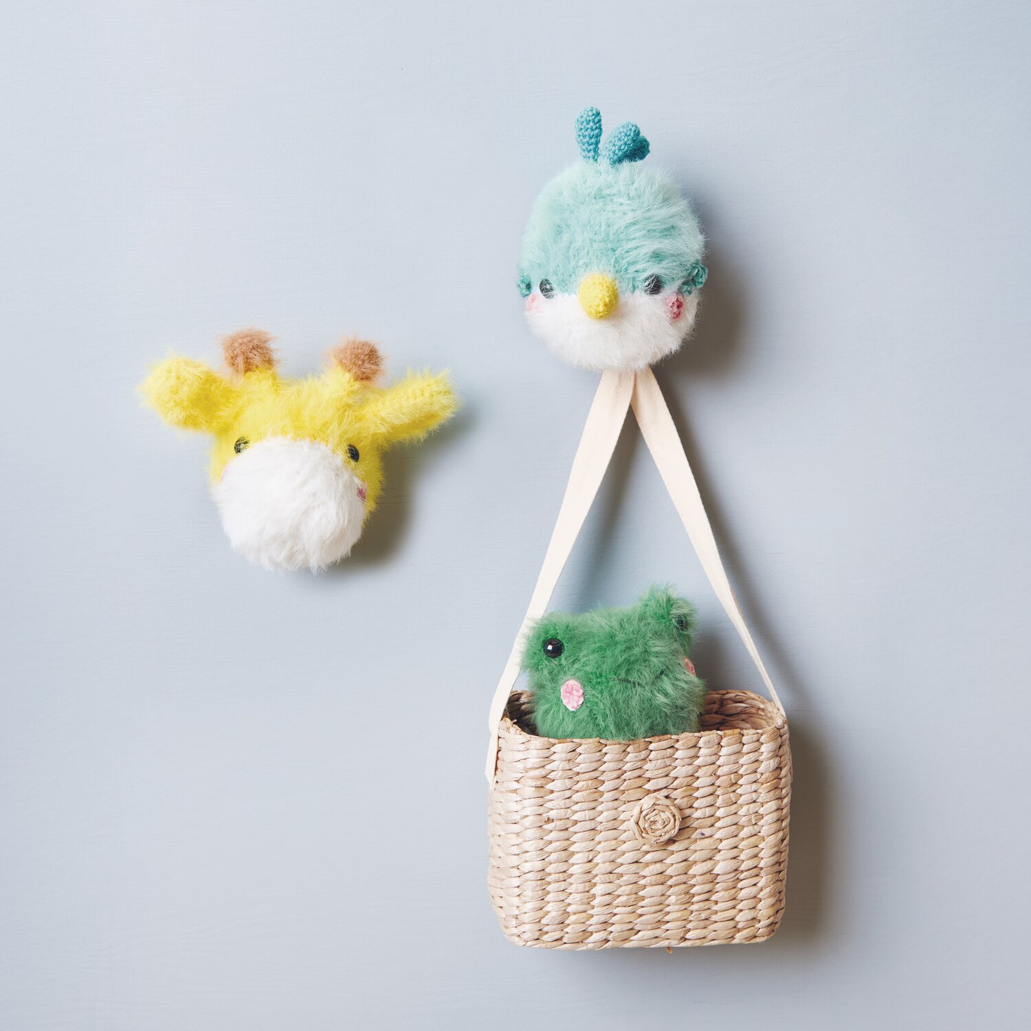 Ricorumi Furry Animals: Flauschige, gehäkelte Tiere in Türkis und Gelb, dekorativ an Korb befestigt.