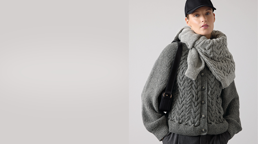 Eine Frau trägt einen aus grauem Garn gestrickten Cardigan und hat einen weiteren Cardigan um den Hals gebunden, daneben ein grauer Farbausschnitt.