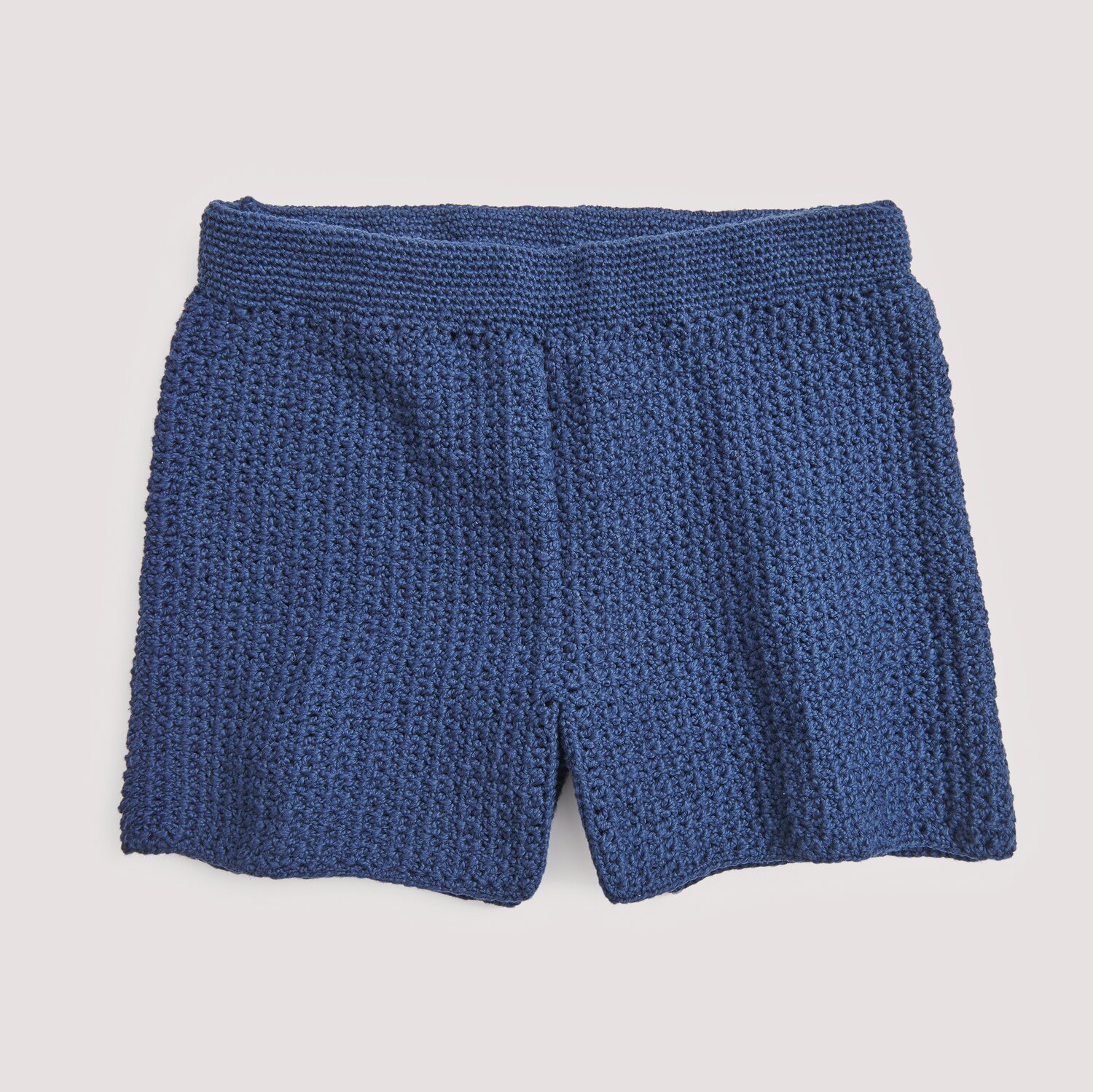 Häkelset Shorts Modell 04 C aus Die Neue Masche No. 15, dunkelblau, gestrickt, auf hellem Hintergrund.