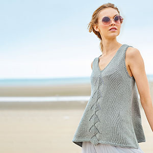 Frau trägt gestricktes Top, im Hintergrund Meer