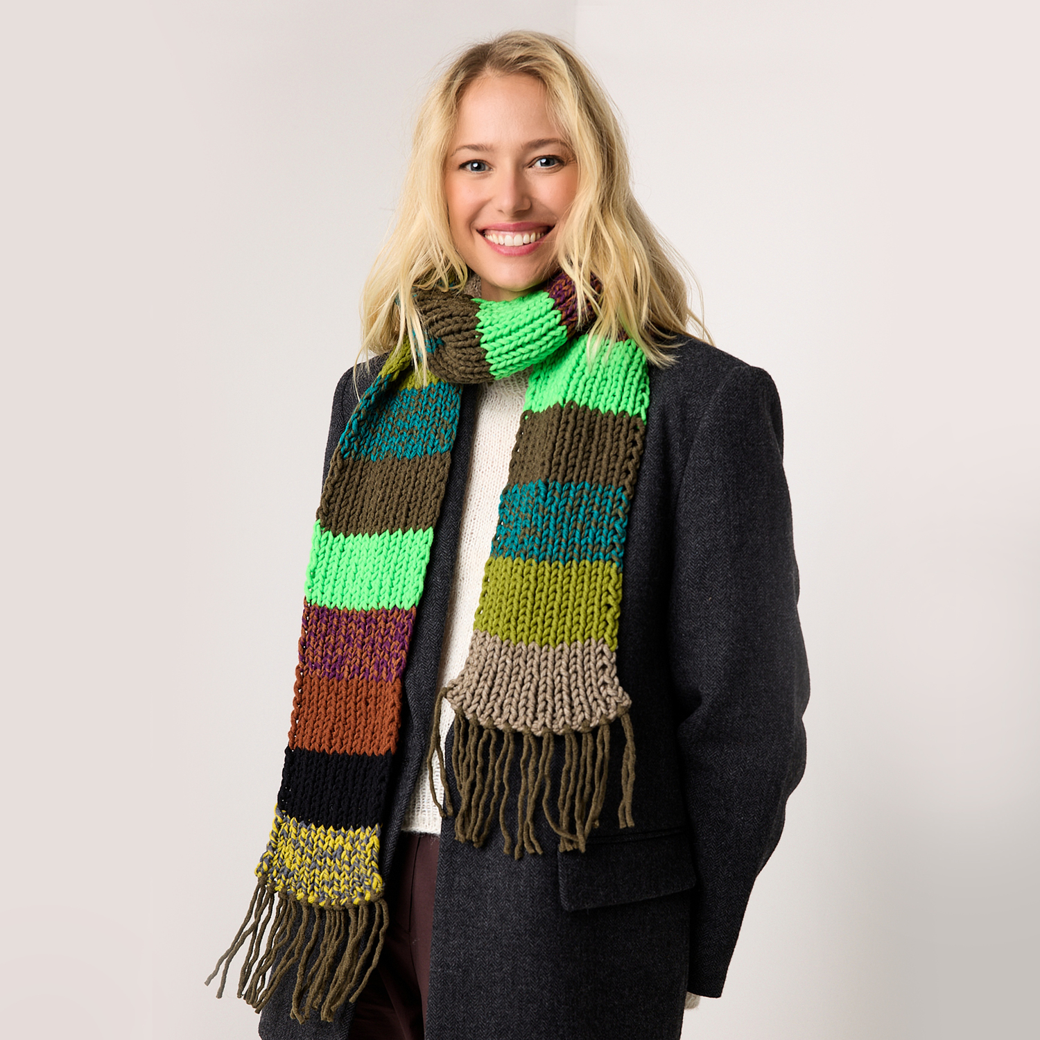 Garnset „Schal des Jahres“: Frau trägt bunten Schal von Wolle Rödel in verschiedenen Grüntönen.