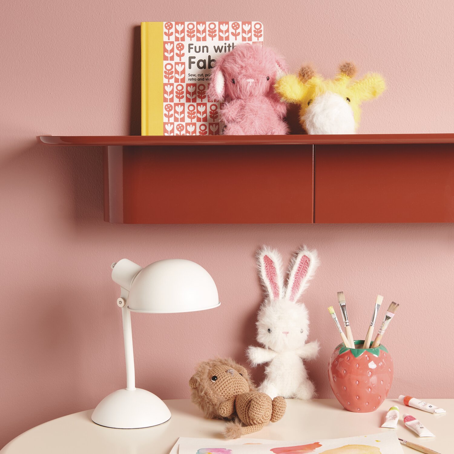 Creative Ricorumi dk 25g Farbe Creme von Rico Design Ricorumi Furry Animals auf Regal mit rosa Wand, umgeben von Deko und weißer Tischlampe.