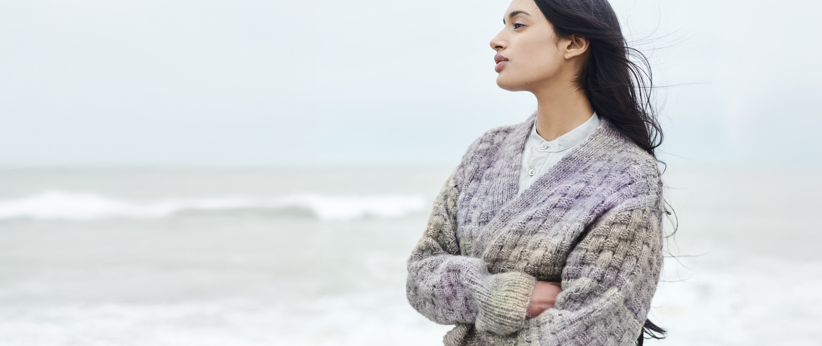 Frau trägt Strickjacke mit Farbverlauf von Lila nach Grün