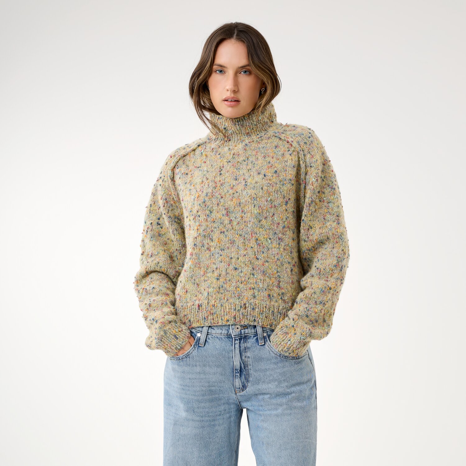 Strickset Pullover Modell 18 aus Die Neue Masche No. 16, hochgeschlossen, locker geschnitten, melierter Strukturstrick, kombiniert mit lässiger Jeans vor hellem Hintergrund