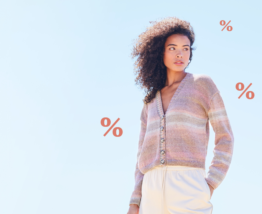 Frau steht mit Strickjacke in Rosatönen vor hellblauem Hintergrund, rote % Zeichen