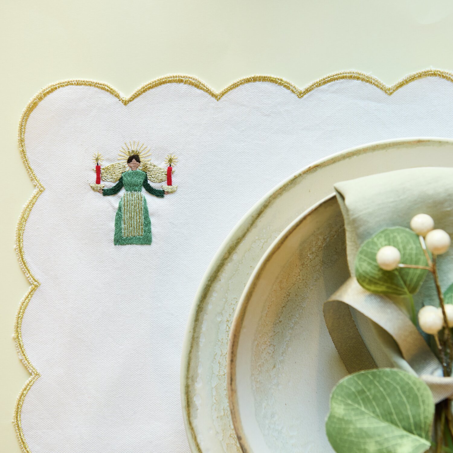 Stick & Stitch Stickpackung Engel mit Kerzen zeigt einen gestickten Engel auf weißem Stoff.