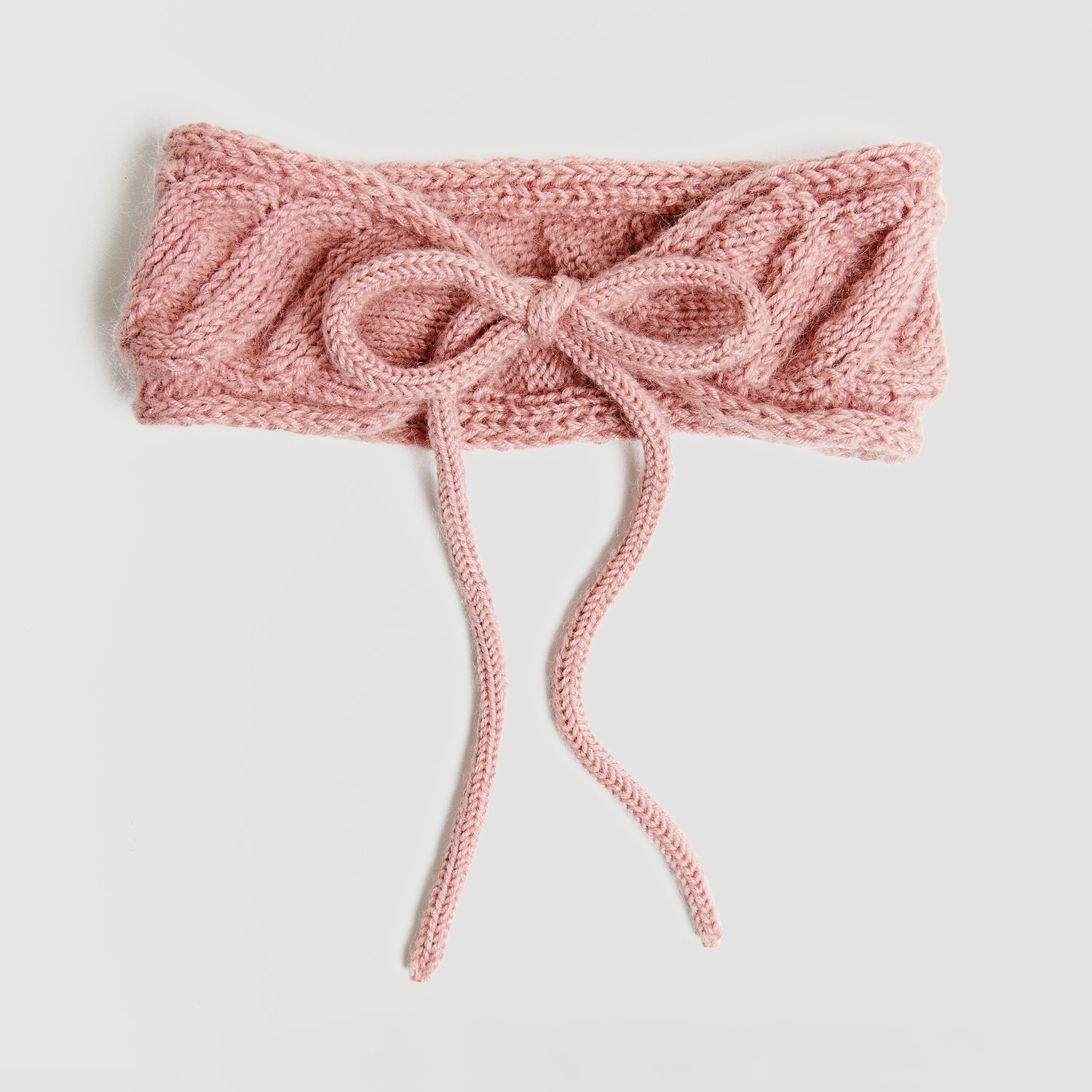 Strickset Stirnband Modell 12 in Perlrosa, gestrickt aus Essentials Merino dk Wolle. Elegantes Design mit Schleife, ideal für den Herbst.