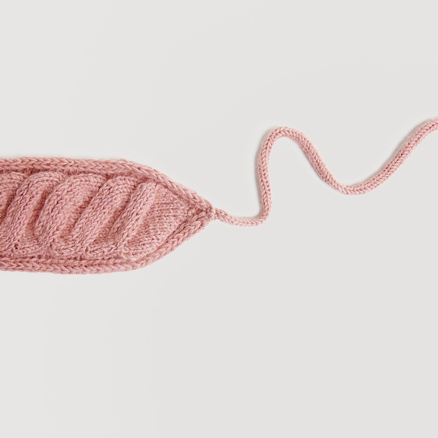 Essentials Merino dk, gestricktes Blatt in Perlrosa, zeigt feine Details und weiche Textur. Ideal für kreative Strickprojekte.