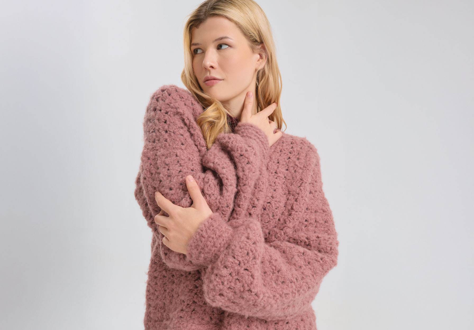 Frau trägt rosa Häkelpullover