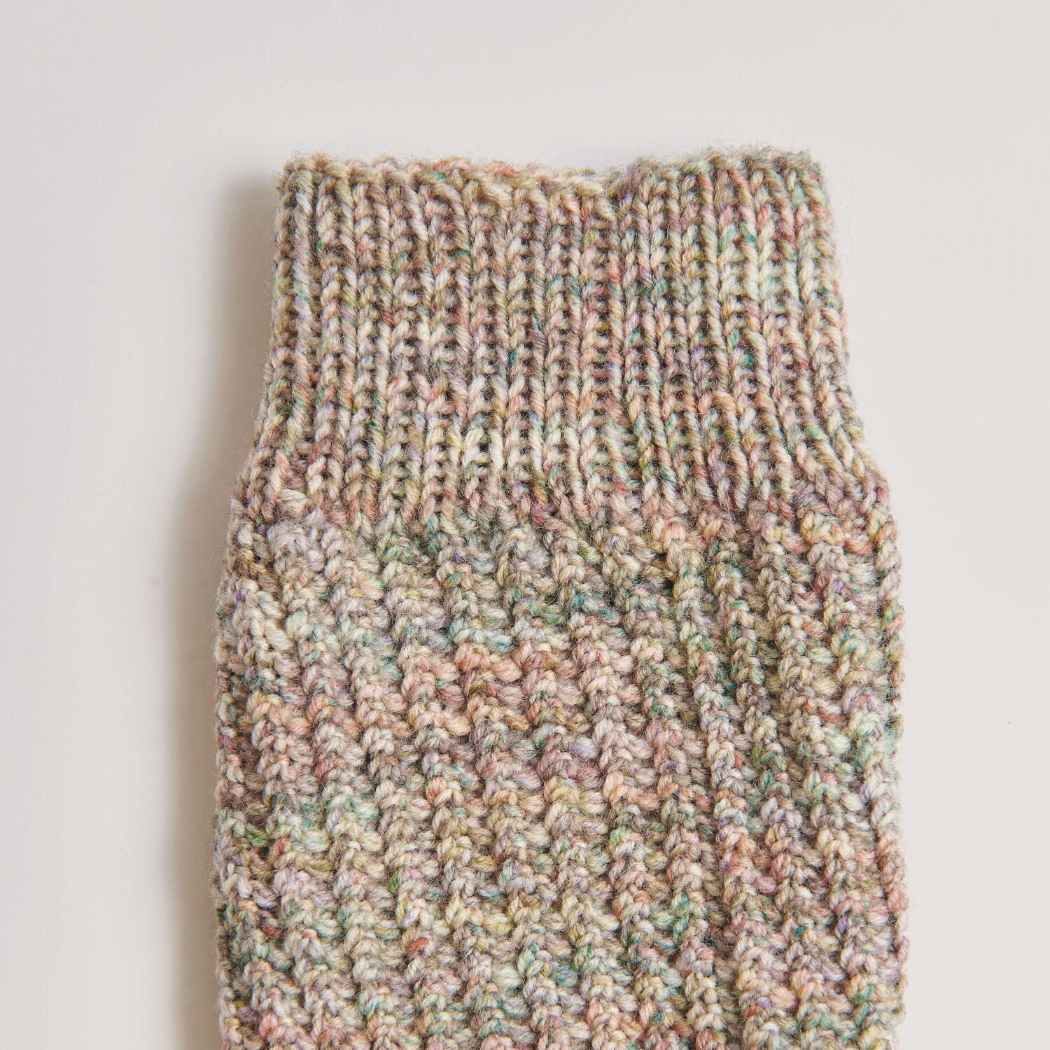 Socks Merino Multicolor 4-fädig, gestrickt aus bunter Wolle, zeigt ein detailreiches Muster.