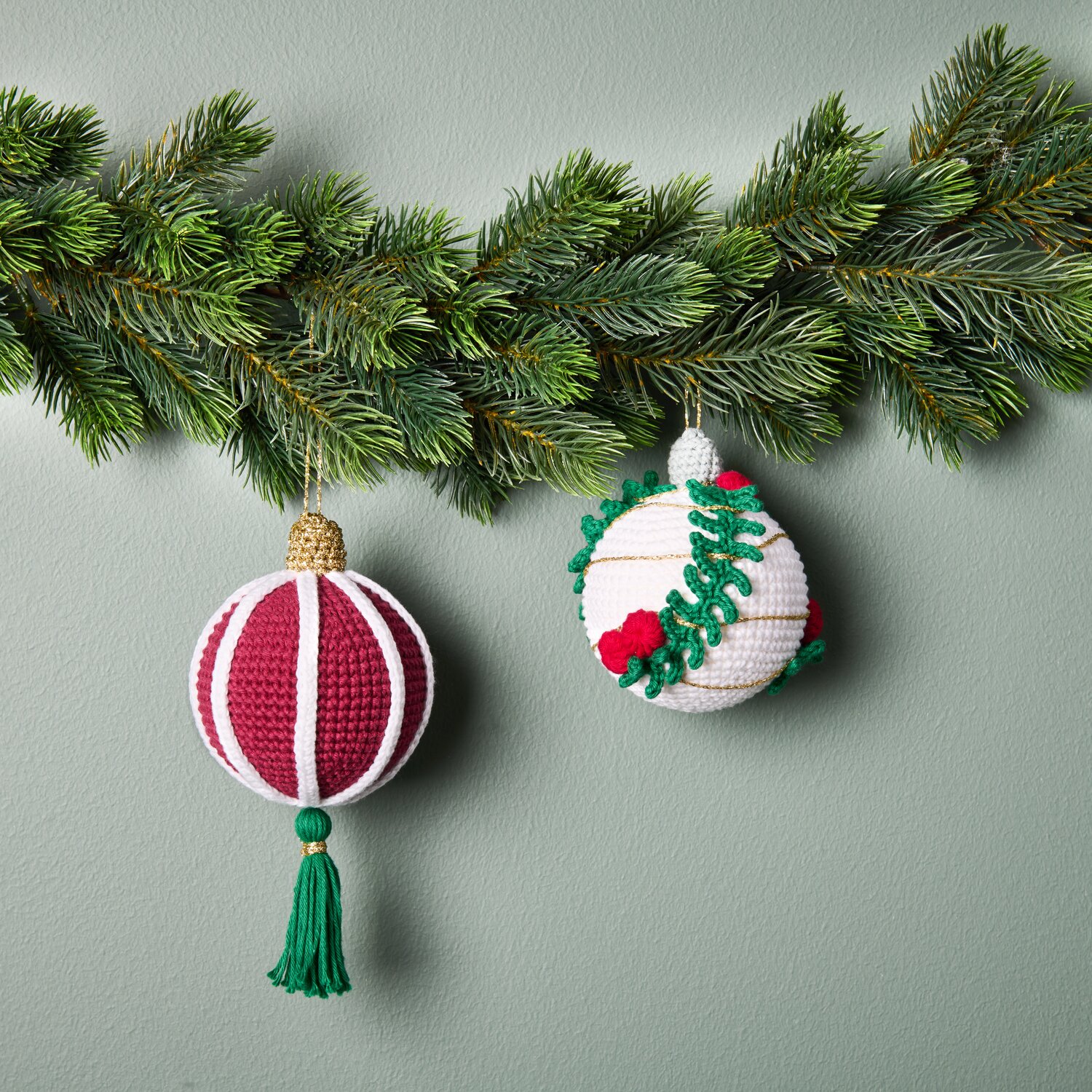 Ricorumi Häkelset Christbaumkugeln Gold 2 Stück von Rico Design Ricorumi Häkelset Christbaumkugeln Gold: Zwei gehäkelte Kugeln in Rot und Weiß an Tannenzweigen.