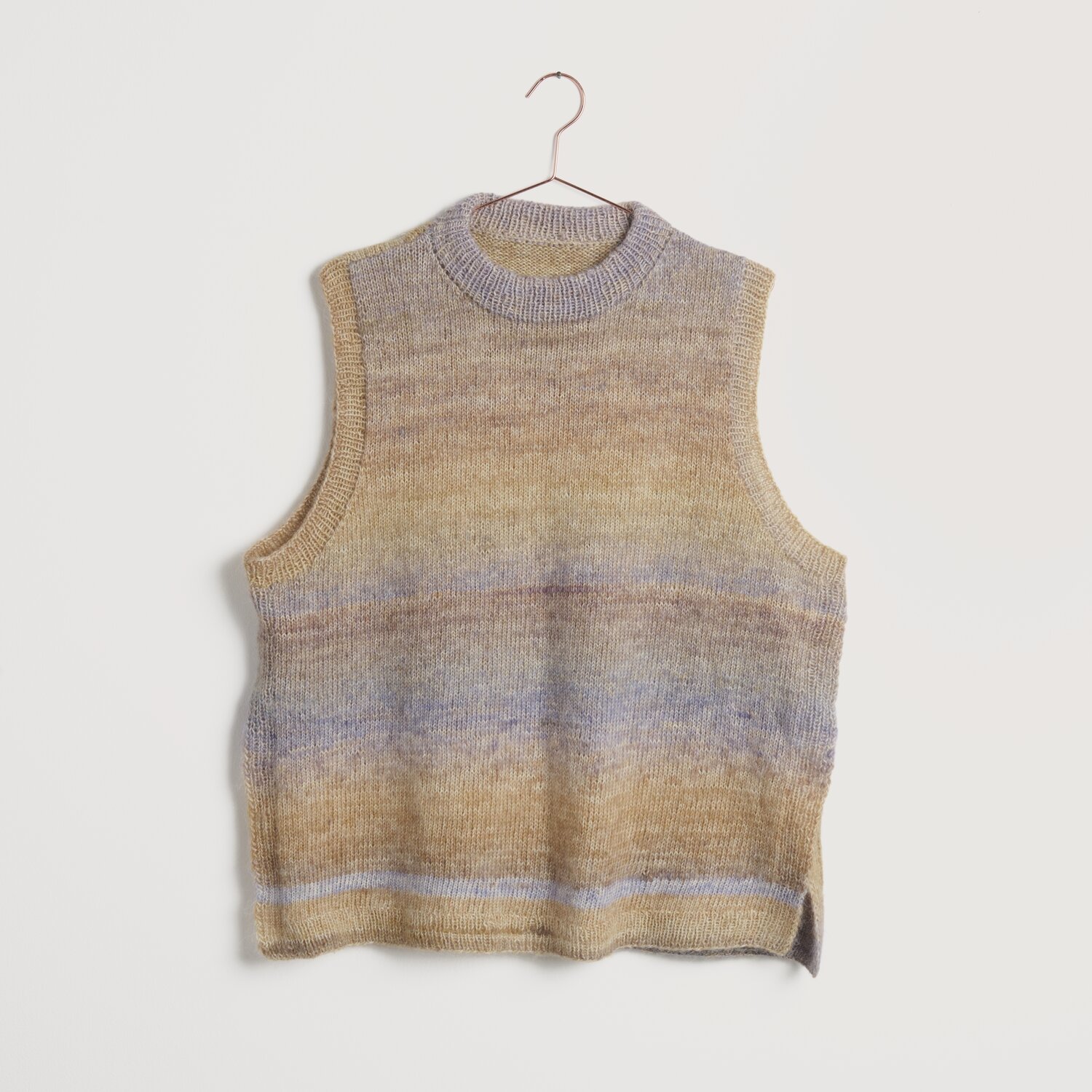 Strickset Pullunder Modell 15 aus Lovewool No. 22, sanfte Erdtöne, ärmellos, auf Bügel.