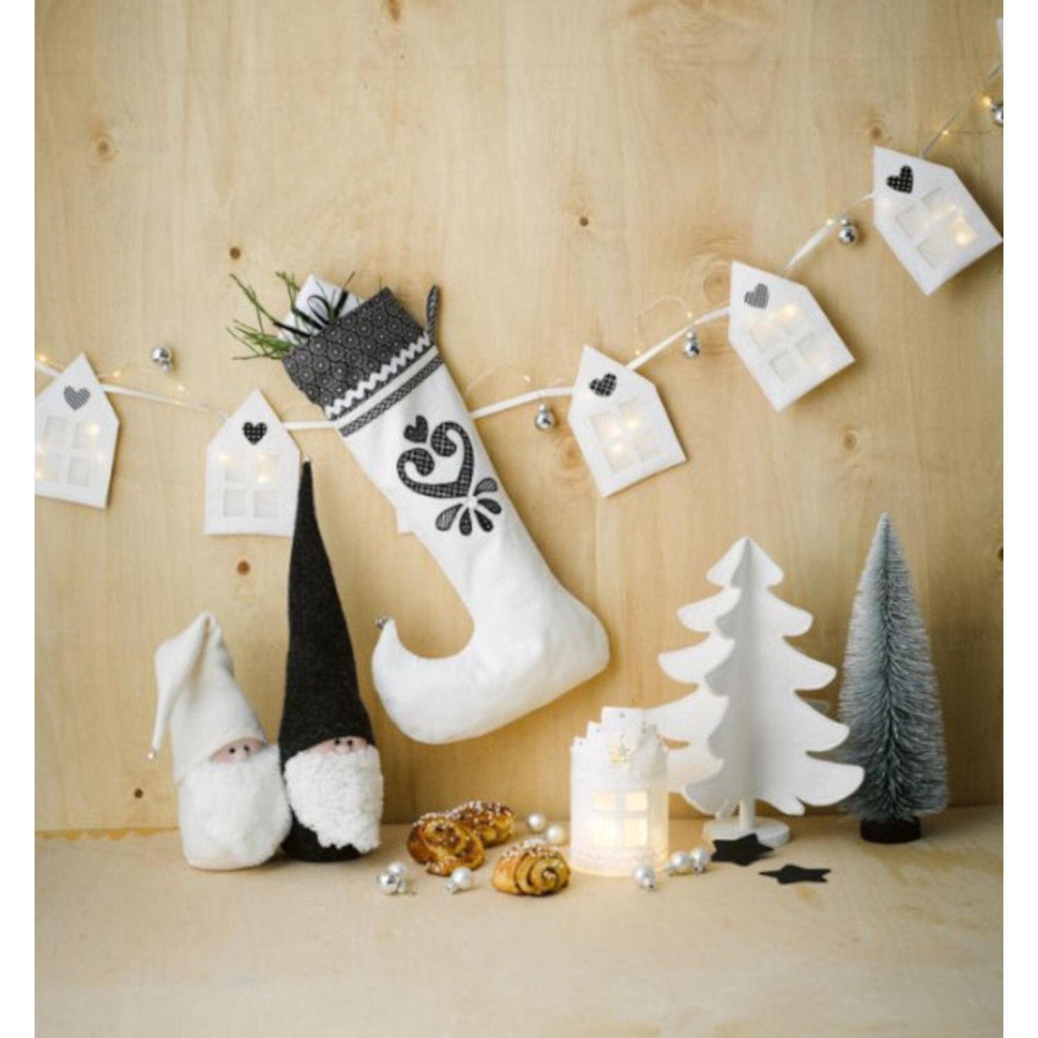 Winterdeko Nähen im Skandi-Stil: Weihnachtliche Szene mit weißem Stiefel, Wichteln und Lichterkette.